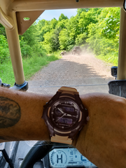 Customer wearing Offroad SAHARA watch while driving a UTV on a dirt trail